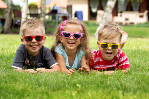 Des enfants sourient allongés dans l'herbe