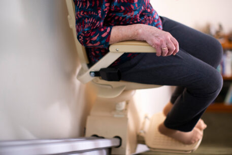Une femme âgée assise sur un monte escalier