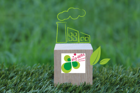 dessin d'une usine sur un socle en bois et logo des éco-défis des commerçants et artisans